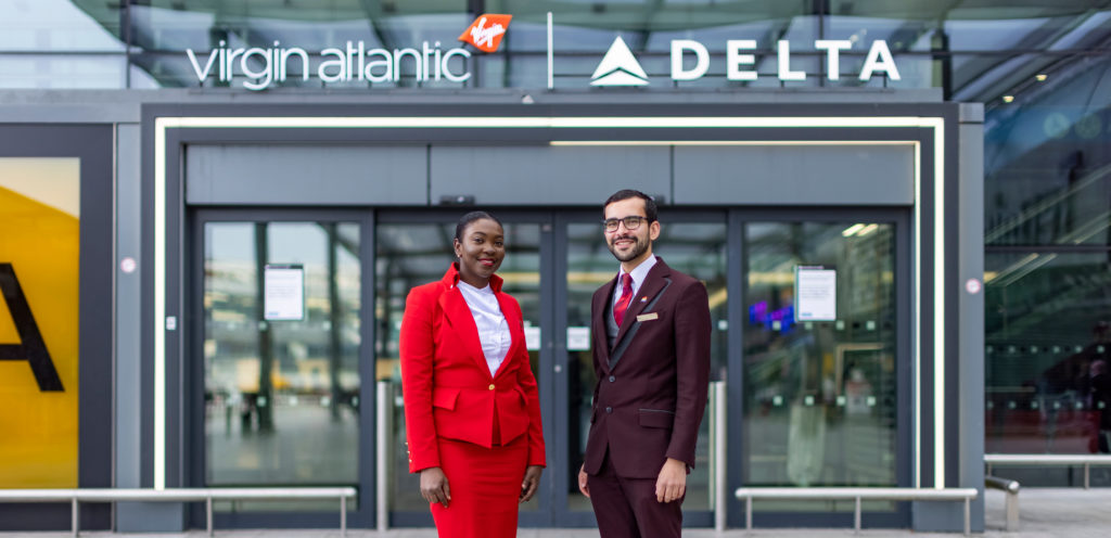 Virgin Atlantic cabin crew in front of Virgin Atlantic and Delta gate