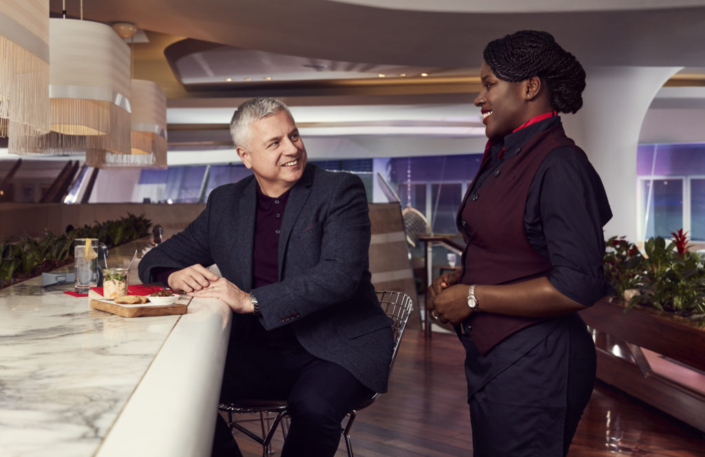 Waiter interacting with Virgin Atlantic Clubhouse visitor at the bar