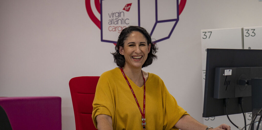 Virgin Atlantic employee at a desk smiling